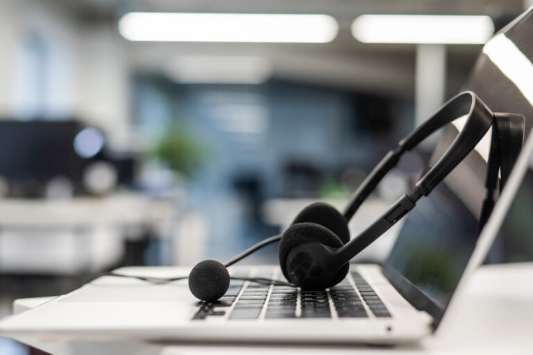 Headset auf Laptop-Tastatur im modernen Büro – Symbol für Kundensupport und IT-Helpdesk.