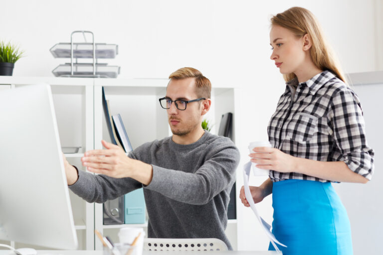 Zwei IT-Spezialisten besprechen Support-Lösungen am Computer im Büro