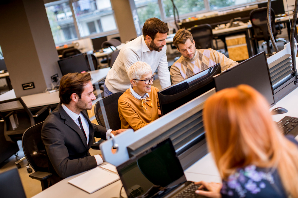 IT-Support-Techniker hilft einem Team von Firmenmitarbeitern bei Computerproblemen