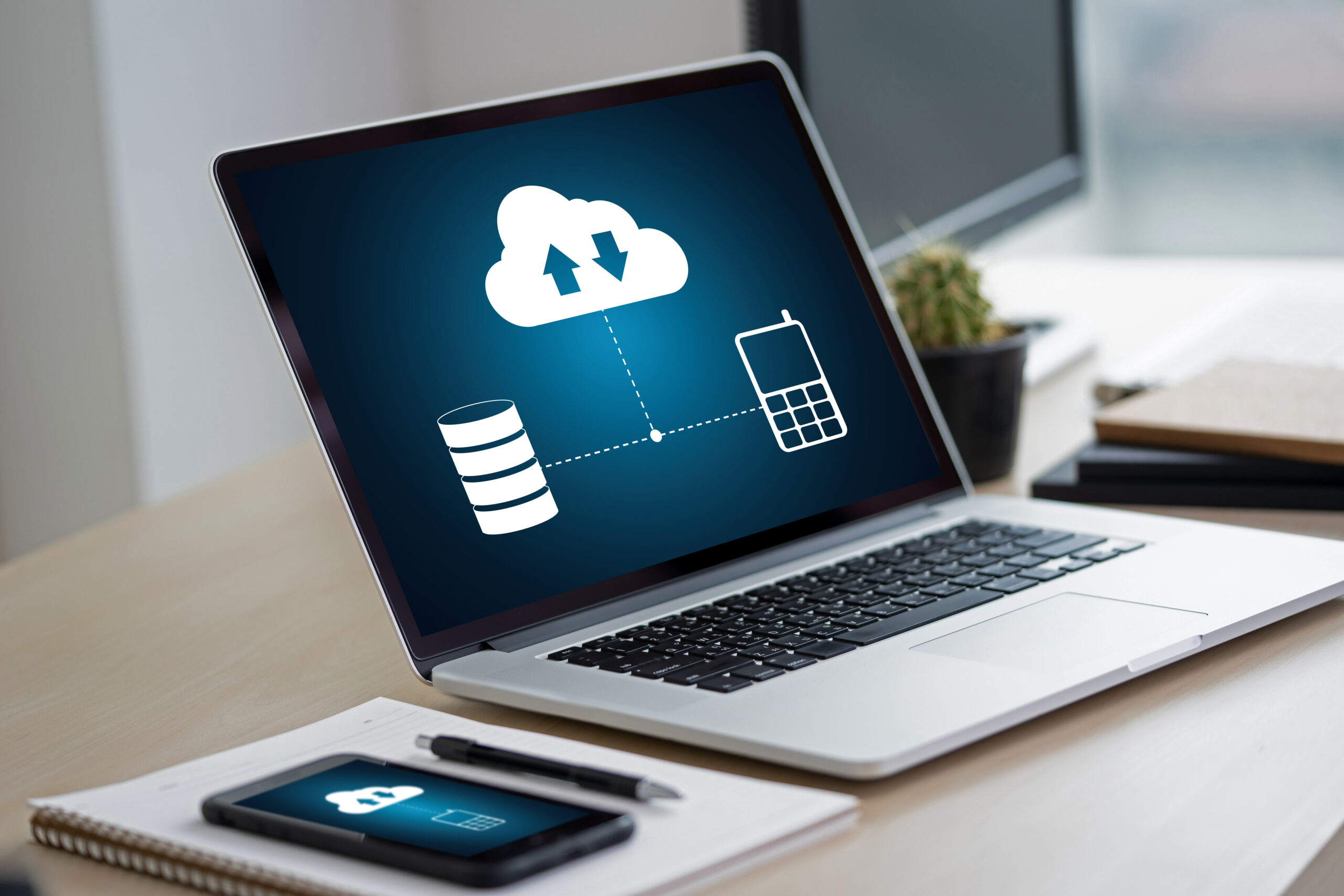 Hände tippen auf Laptop-Tastatur mit eingeblendetem Cloud-Symbol – Symbol für Cloud-Dienste und Microsoft 365.