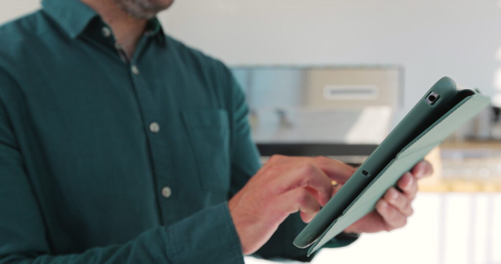 Person hält Tablet in der Hand und arbeitet in moderner Umgebung