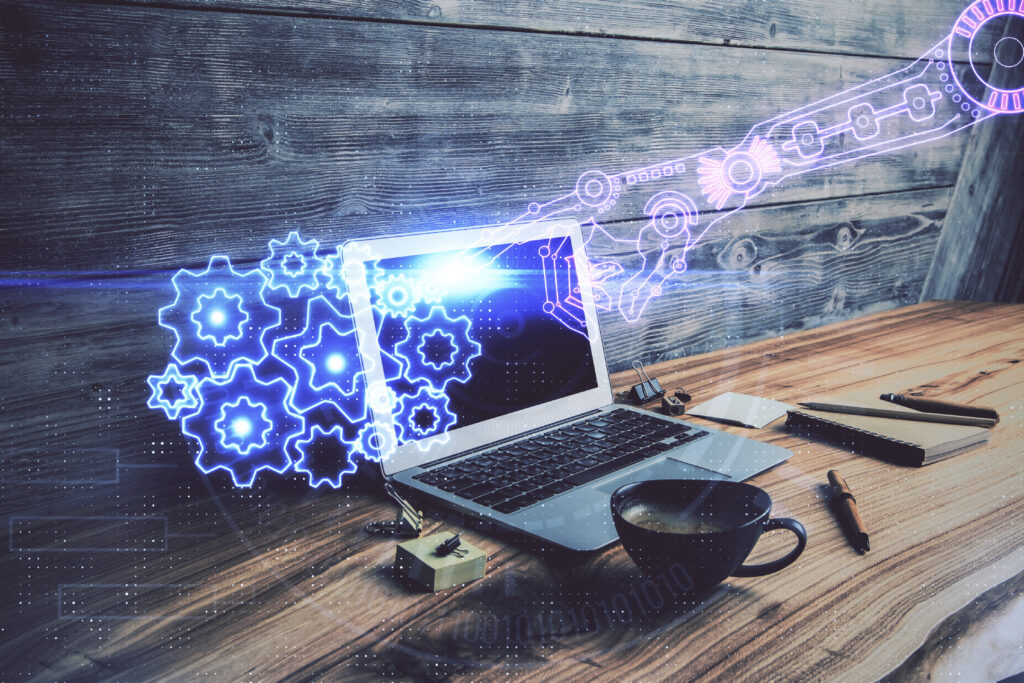 Laptop mit digitalen Zahnrädern und Tech-Grafiken als Symbol für Automatisierung