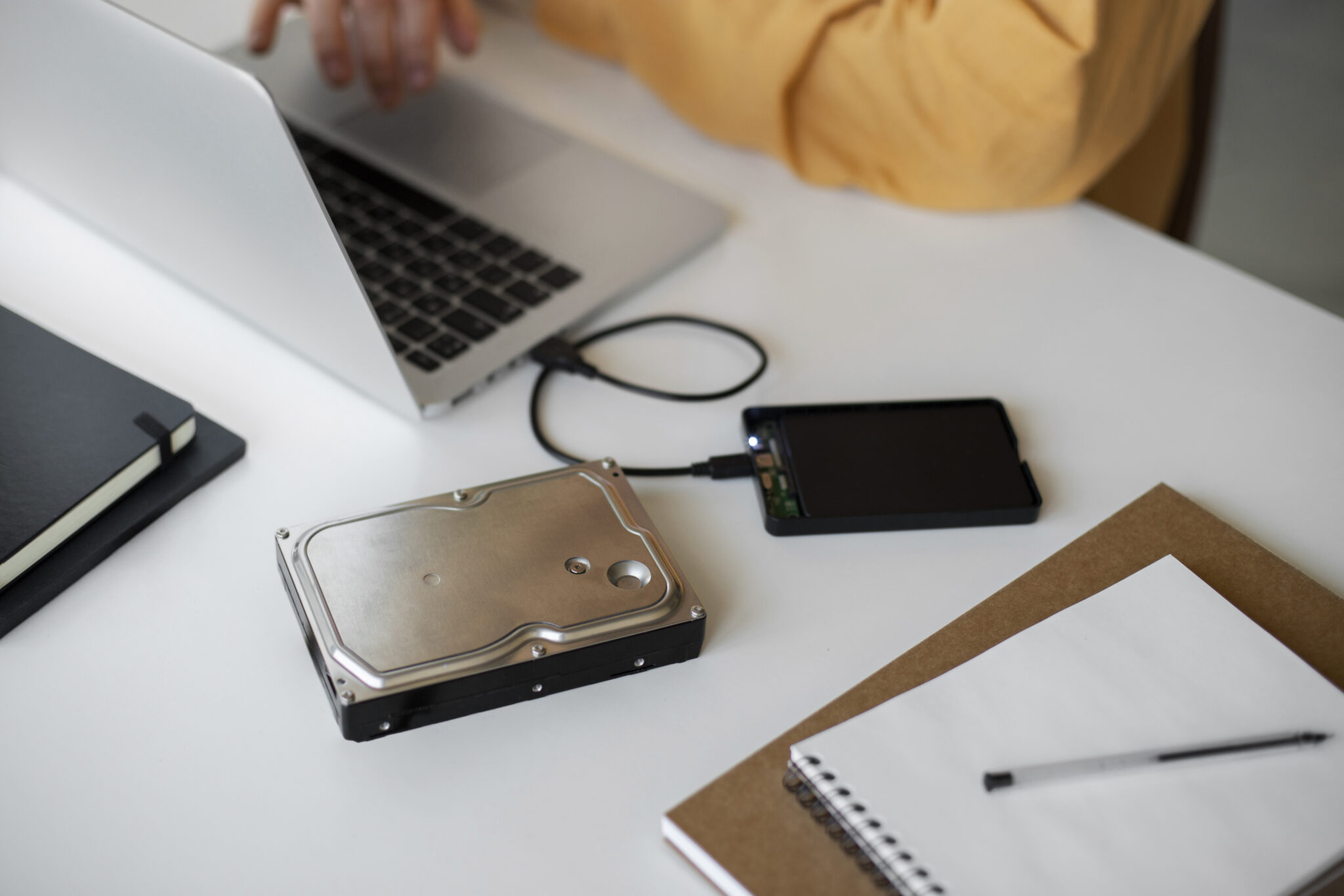 Laptop mit angeschlossenen Backup-Festplatten auf dem Schreibtisch