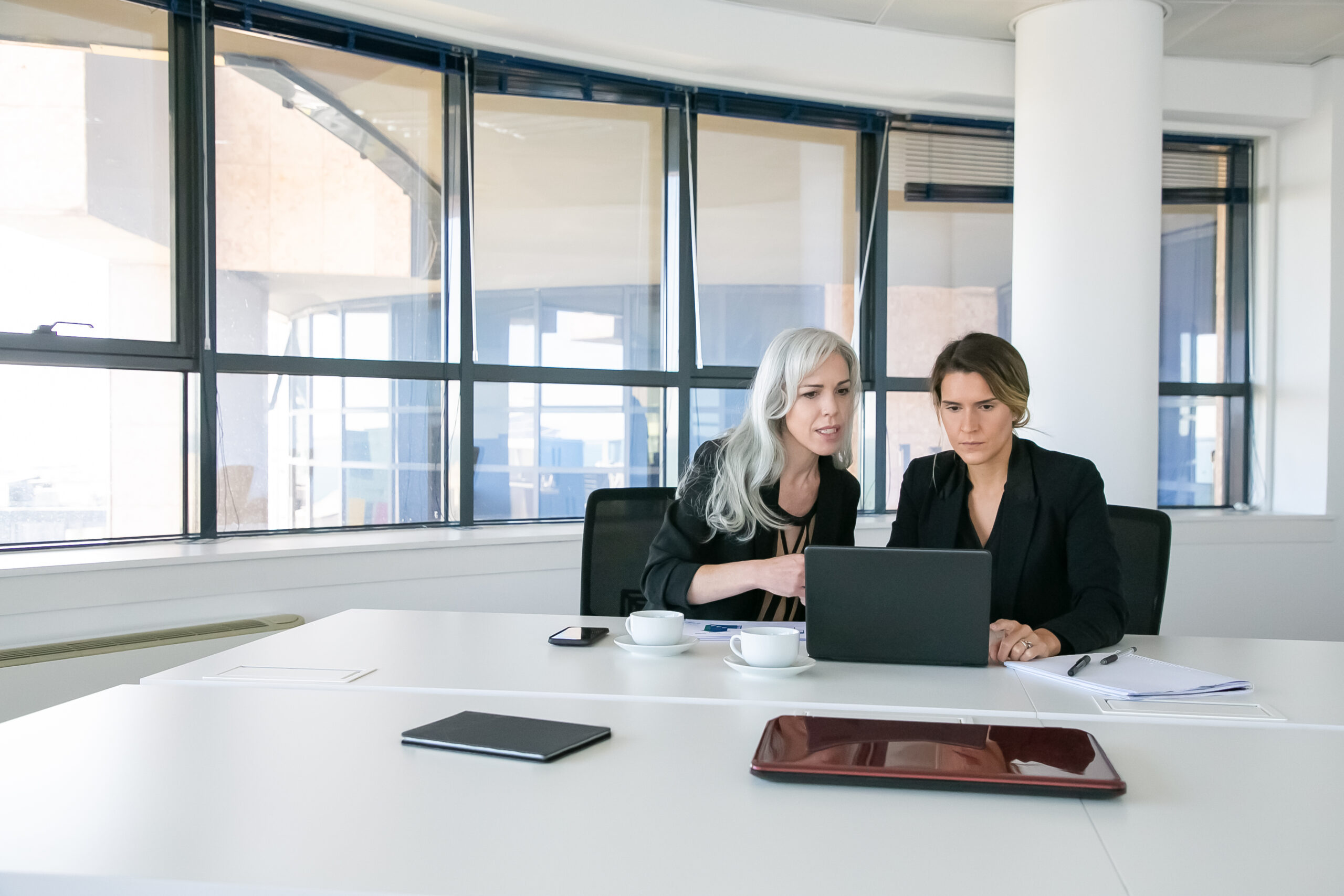 Junger Mann und Frau bei gemeinsamer Arbeit am Laptop im Büro