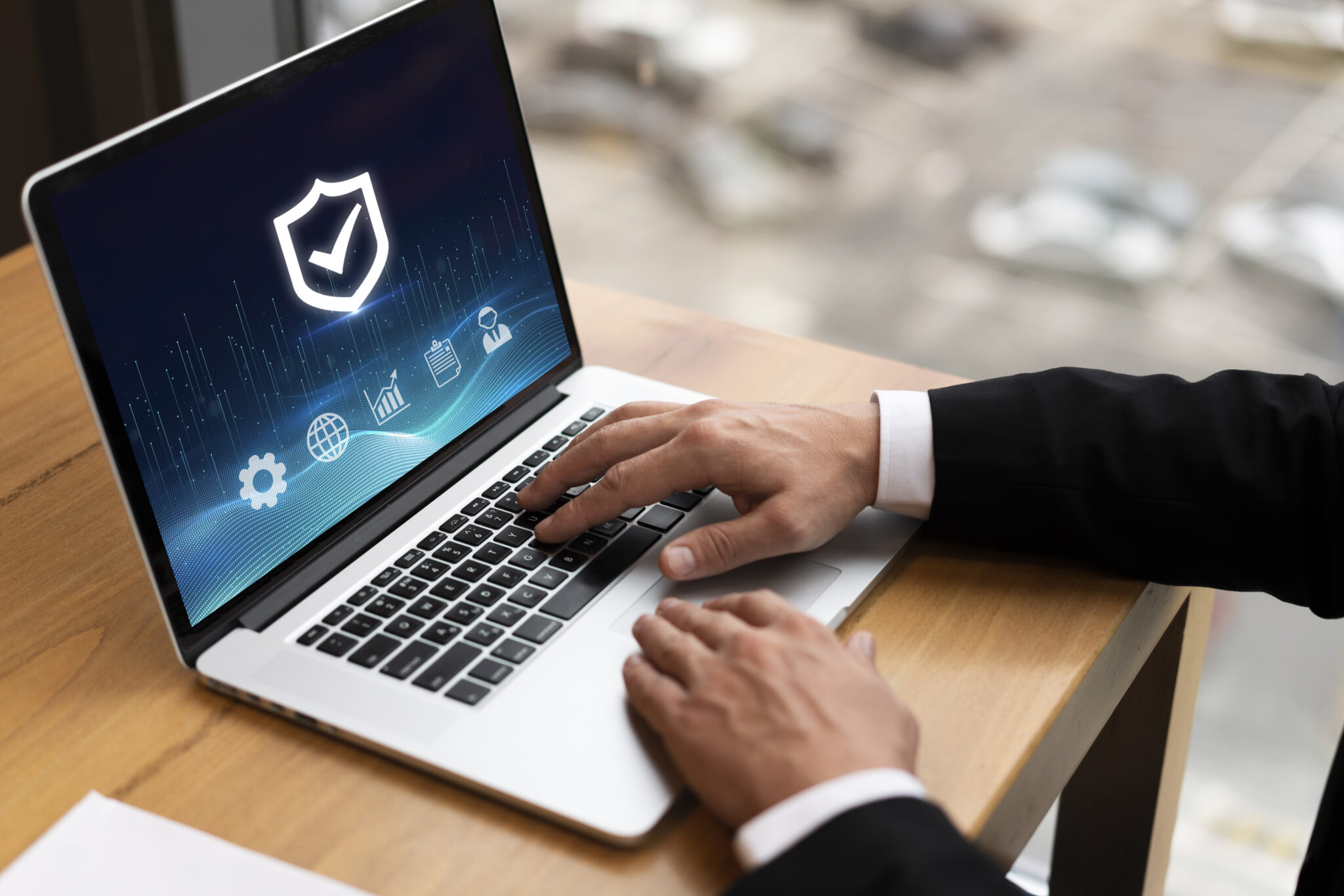Business-Nutzer arbeitet am Laptop mit IT-Sicherheitssymbol auf dem Bildschirm