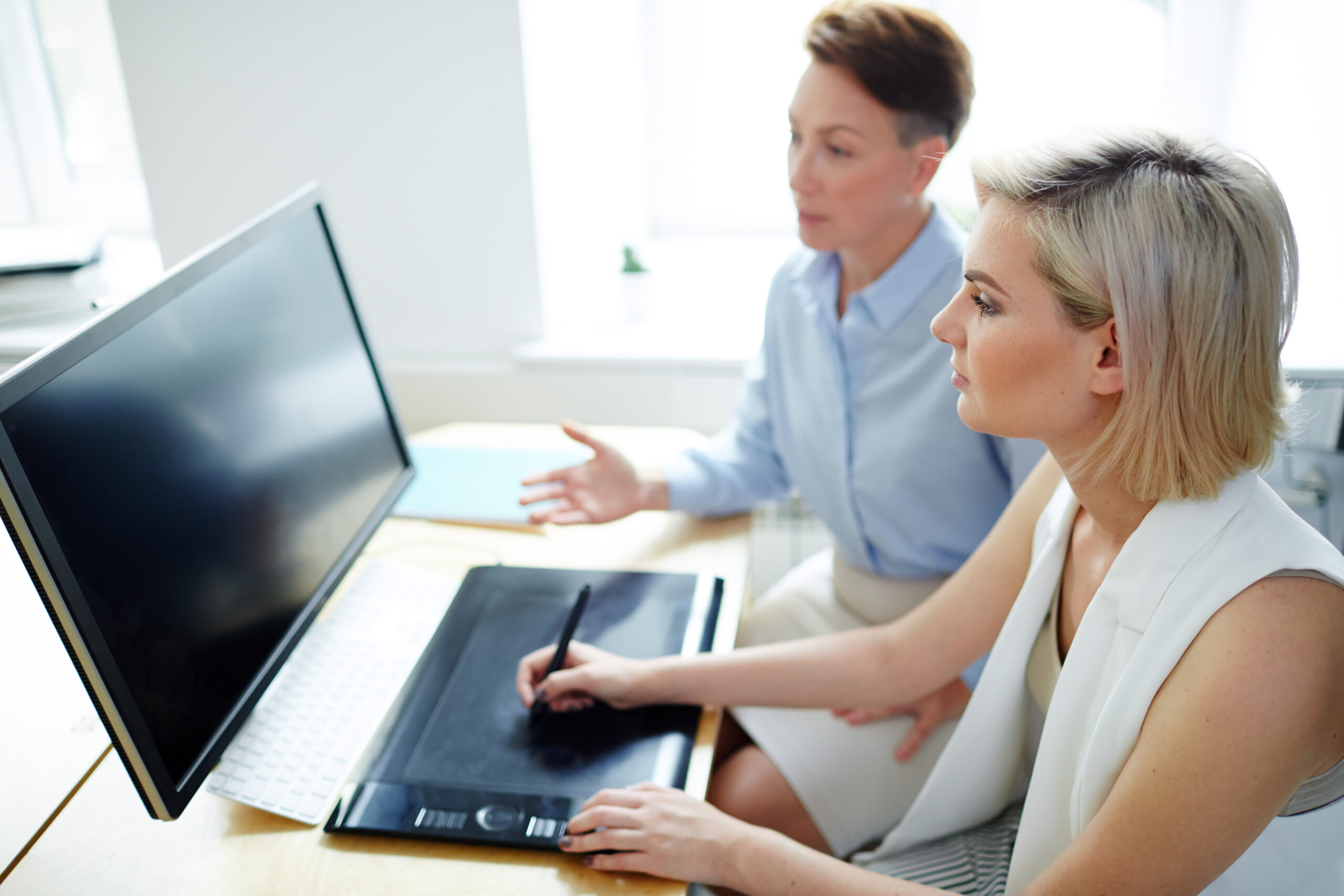 Zwei Geschäftsleute besprechen EDV-Konzepte mit Grafiken und Laptop