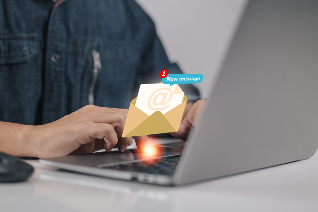 Frau arbeitet am Computer mit eingeblendeten E-Mail-Symbolen