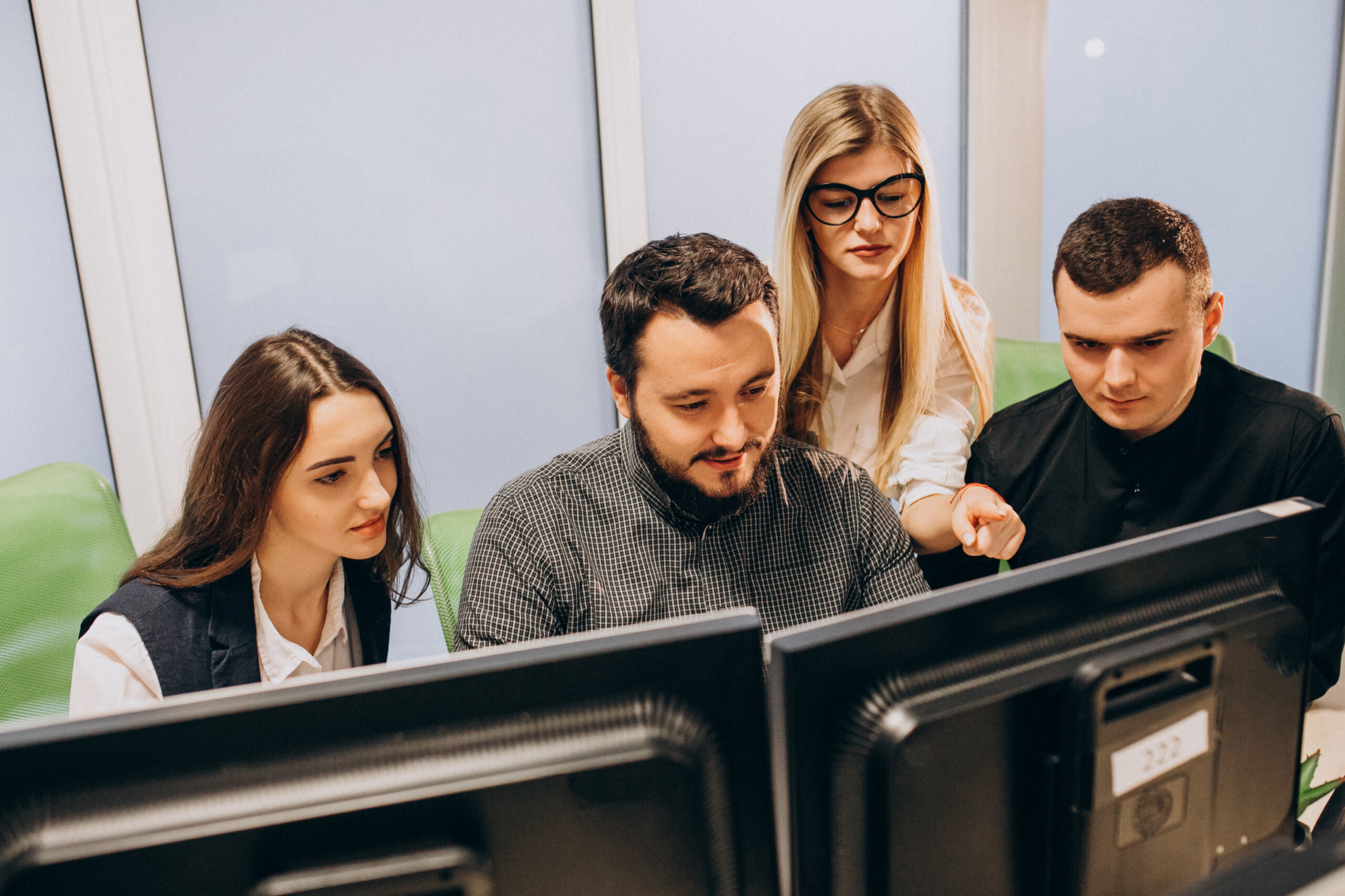 Team von IT-Fachleuten überwacht Unternehmenssysteme an Arbeitsplätzen mit mehreren Monitore