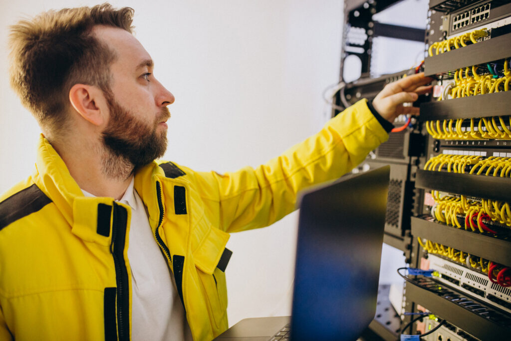 Techniker in Wien überprüft Netzwerkverkabelung und Serversysteme