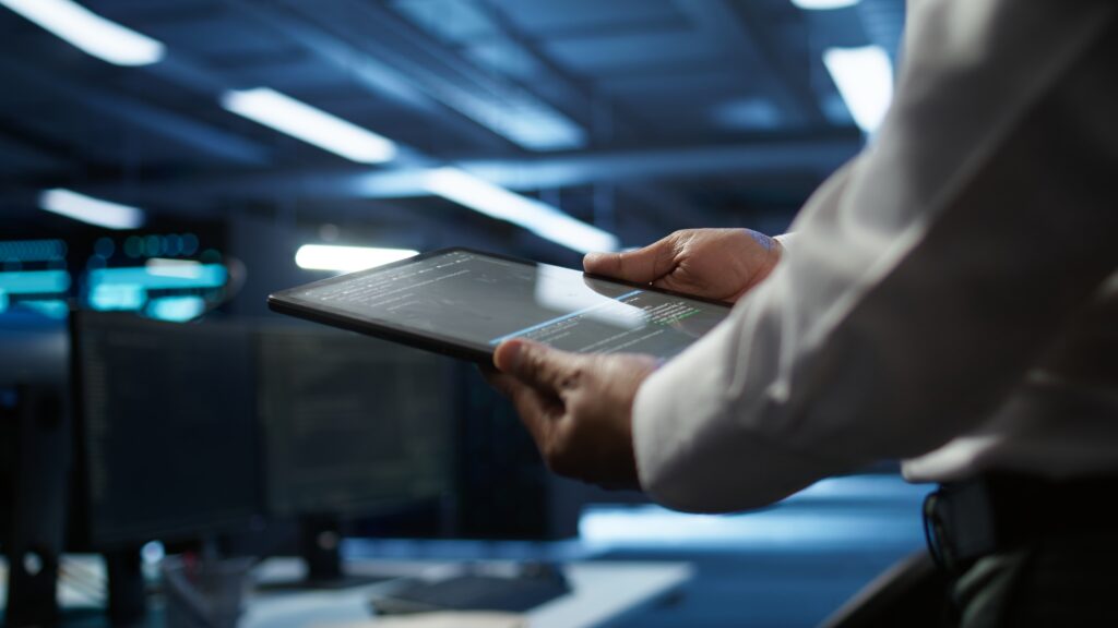 IT-Fachkraft überprüft Systemdaten auf einem Tablet im Rechenzentrum