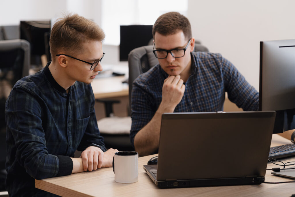 Zwei IT-Spezialisten analysieren Daten und Systeme an Monitoren in einem Rechenzentrum