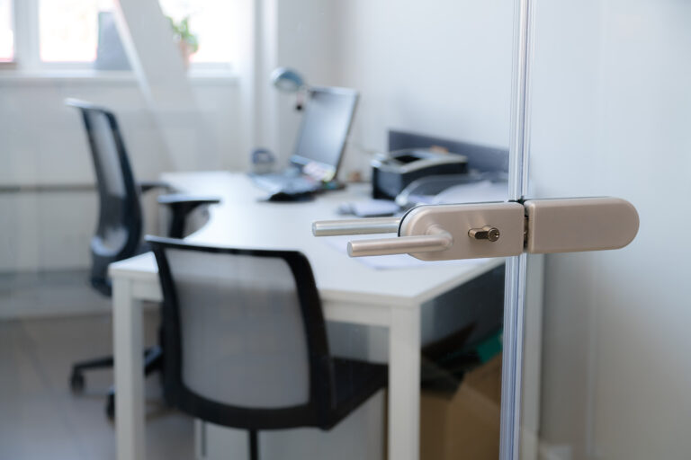 Moderner Arbeitsplatz im Büro mit Glaswand und Schreibtisch – Symbol für Arbeitsumgebung