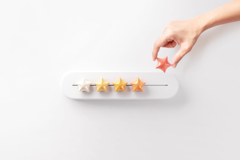 Hand setzt fünften Stern – Symbol für Bewertung, Erfolg und Optimierung durch Technology Business Reviews